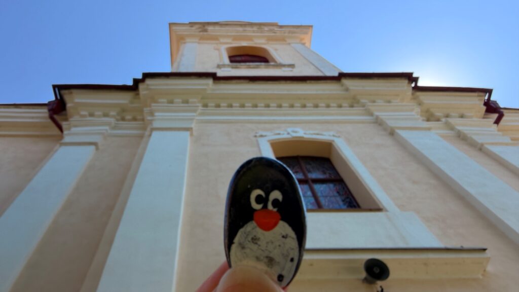 Hand-painted penguin stone #1148 hidden at Church of St Bartholomew the Great, Hniezdne, Slovakia