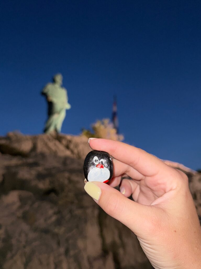 Hand-painted penguin stone #969 hidden at Rocks Underneath Statue, Makarska, Croatia