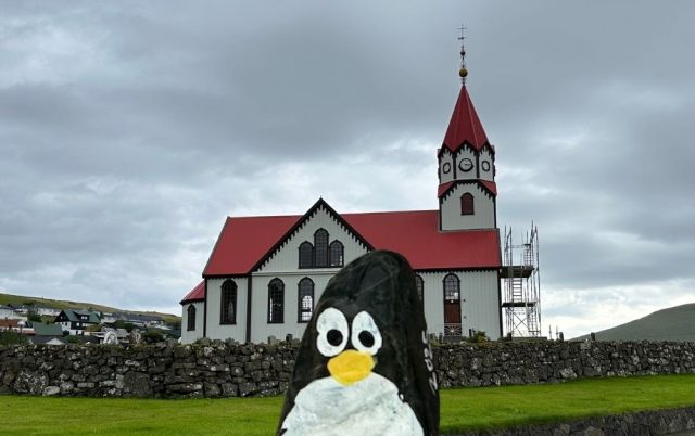 Hand-painted penguin stone #1066 hidden at Sandavags Kirkja, Sandavagur, Faroe Islands