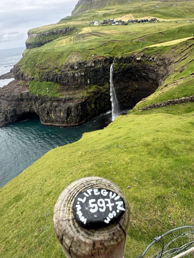 Hand-painted penguin stone #597 hidden at Mulafossur Waterfall, Gasadalur, Faroe Islands (photo 2 of 5)