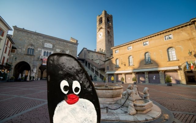 Hand-painted penguin stone #927 hidden at Monumento alla Lente, Bergamo, Italy