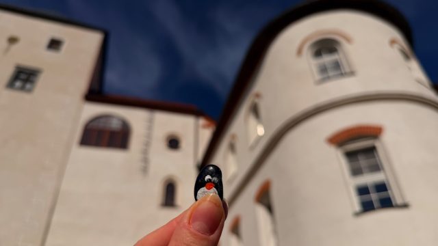 Hand-painted penguin stone #1135 hidden at Mathias Bel Statue at Lupca Castle, Slovenska Lupca, Slovakia