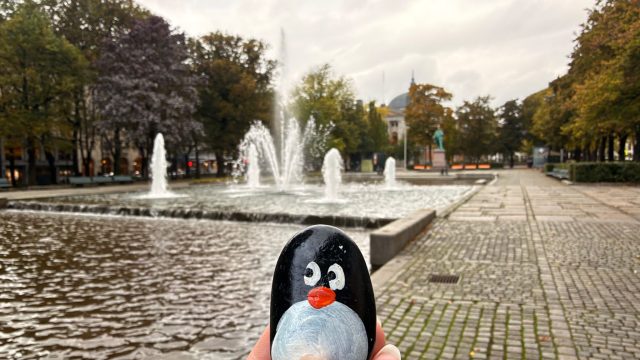 Hand-painted penguin stone #1472 hidden at Rainbow Square Tree Hole, Oslo, Norway