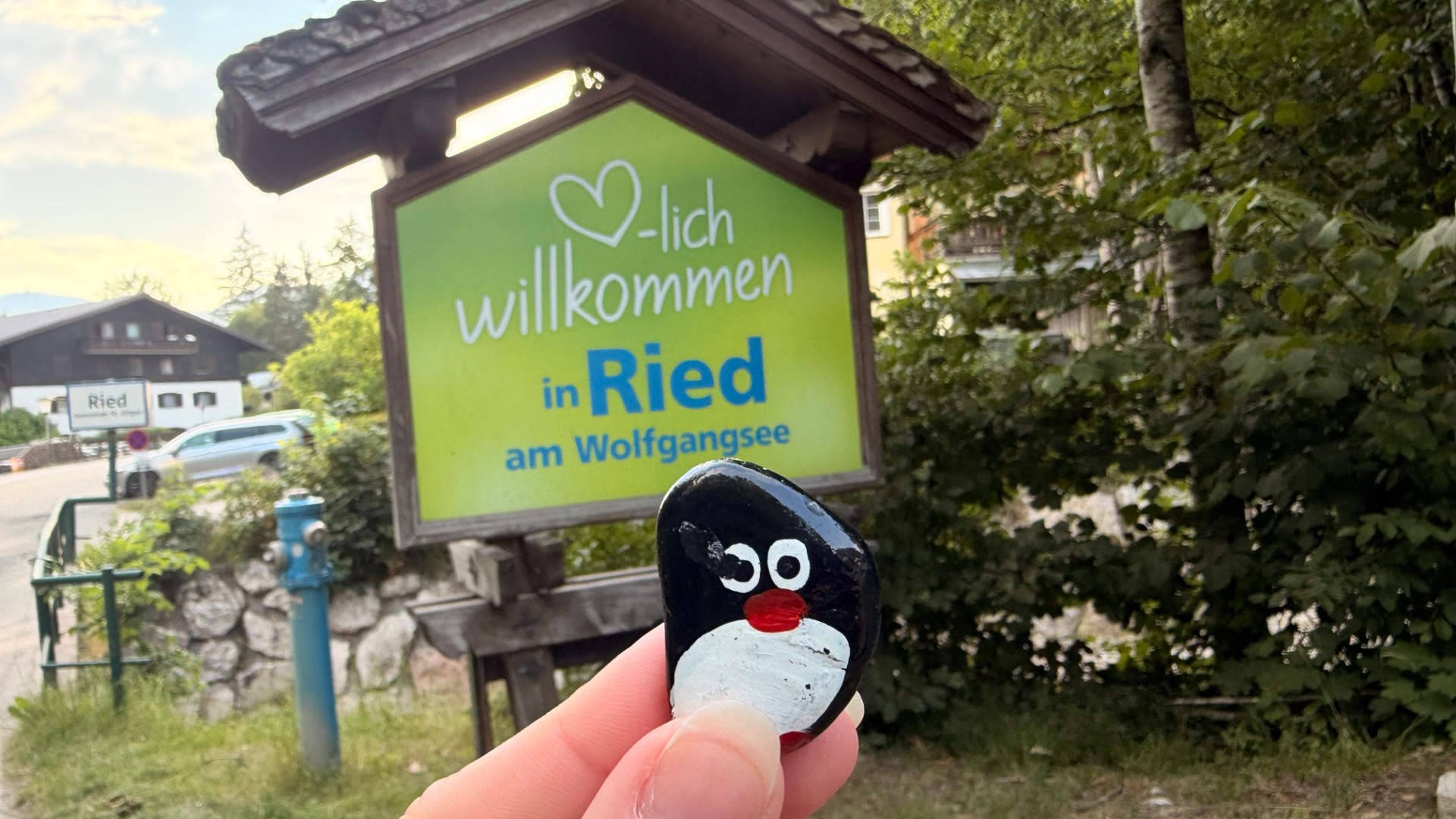 Hand-painted penguin stone #1265 hidden at Welcome in Ried Sign, St. Wolfgang im Salzkammergut, Austria (photo 1 of 5)
